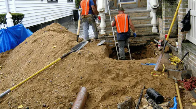 Contractors performing foundation protection and exterior drainage excavation near residential home steps in Salt Lake City, UT